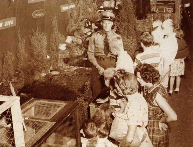 صورة بالأبيض والأسود لحارس صيد يتحدث إلى الأطفال