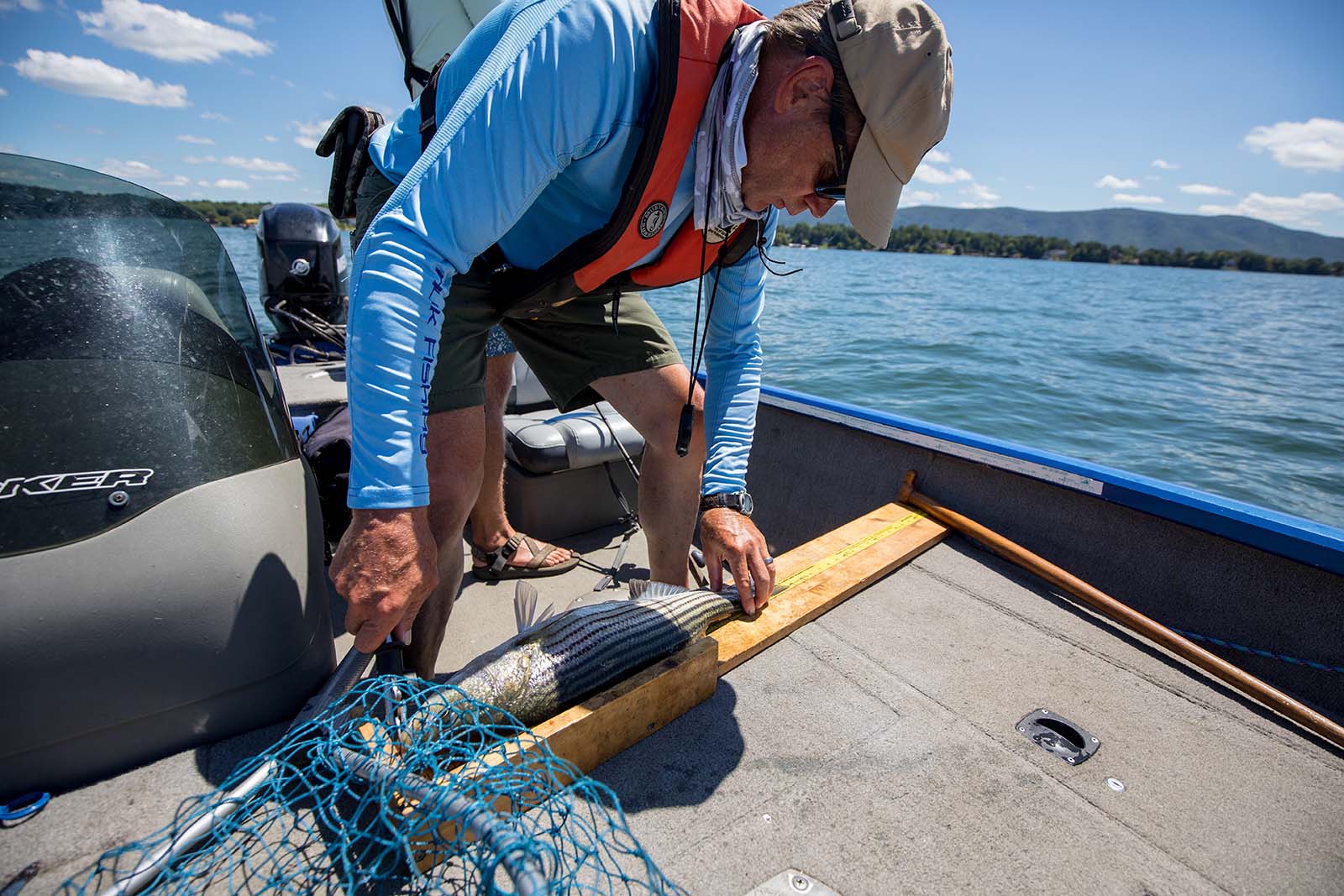 عالمة أحياء تقيس سمكة على لوح