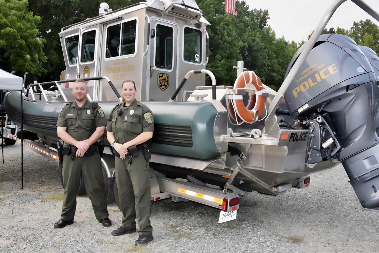 ضباط الشرطة المدنية يقفون أمام قارب شرطة على مقطورة