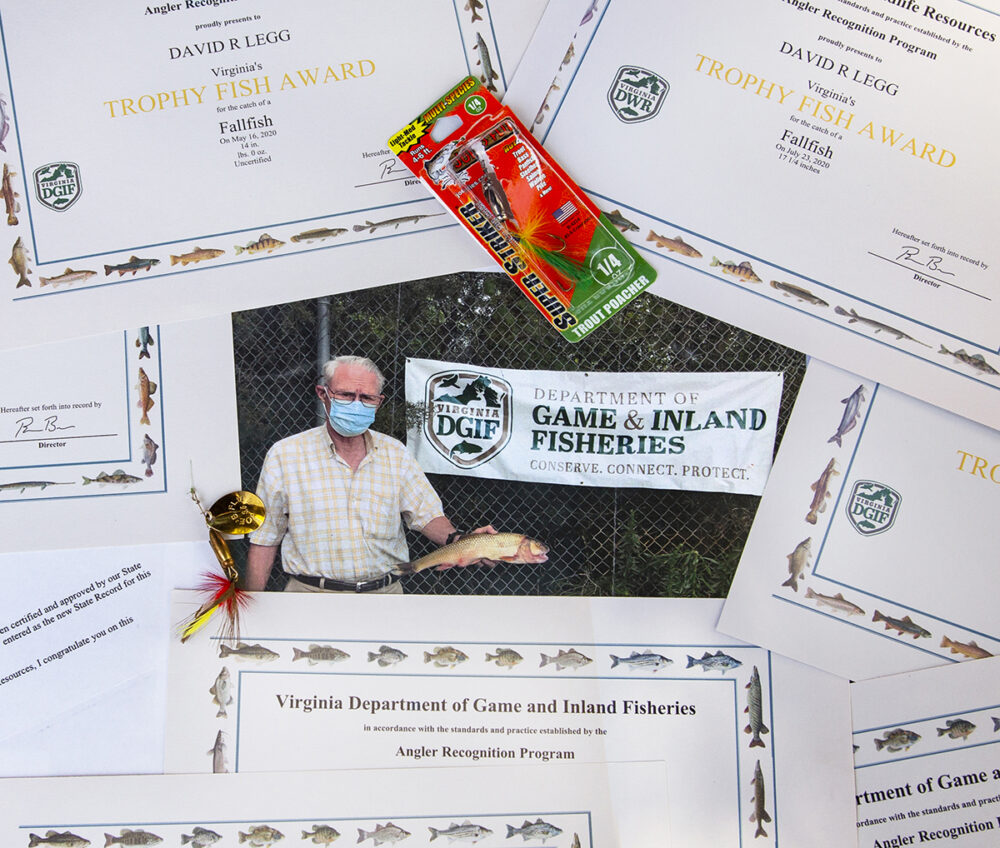 صورة للصياد الذي اصطاد السمكة التي حطمت الرقم القياسي محاطًا بالعديد من الجوائز التي فاز بها على مر السنين