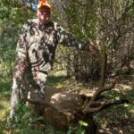 رجل يقف مع ظبي نافق تم اصطياده.