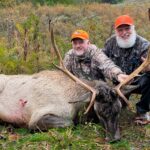 رجلان يقفان مع غزال نافق.