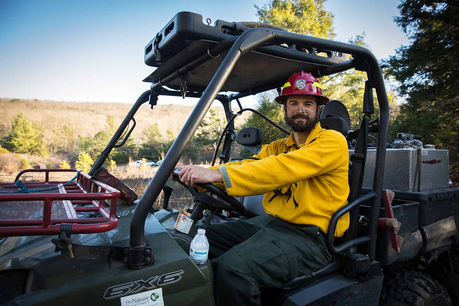 أحد أفراد طاقم الإطفاء يقود مركبة لجميع التضاريس.