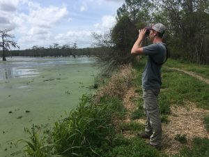 شخص يحمل منظاراً ينظر من خلال بركة ماء