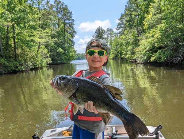 سوير (العمر 7)، ممسكًا بسمكة