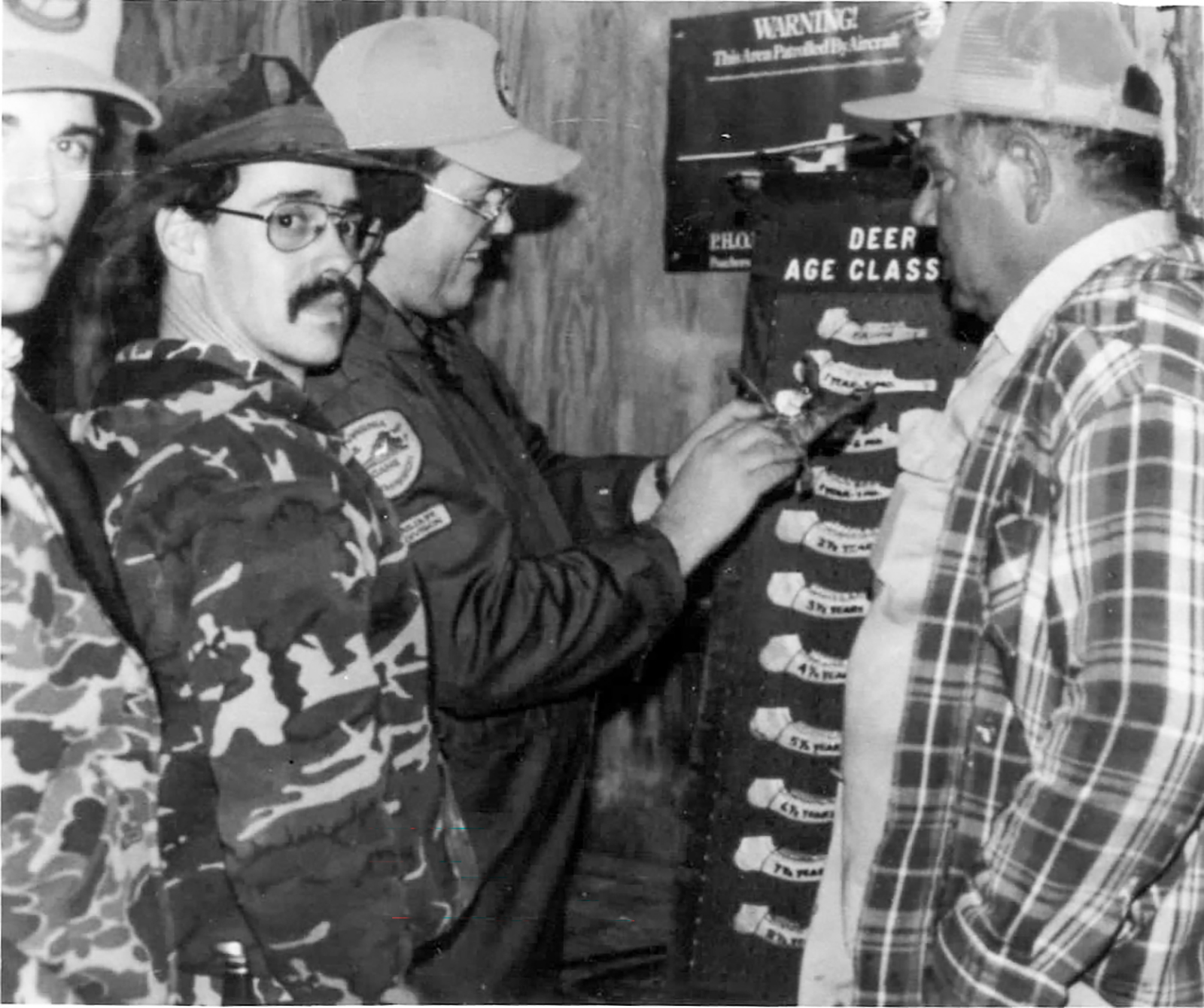 صورة قديمة بالأبيض والأسود تُظهر الصيادين وهم يقيسون عظام فك الغزلان.