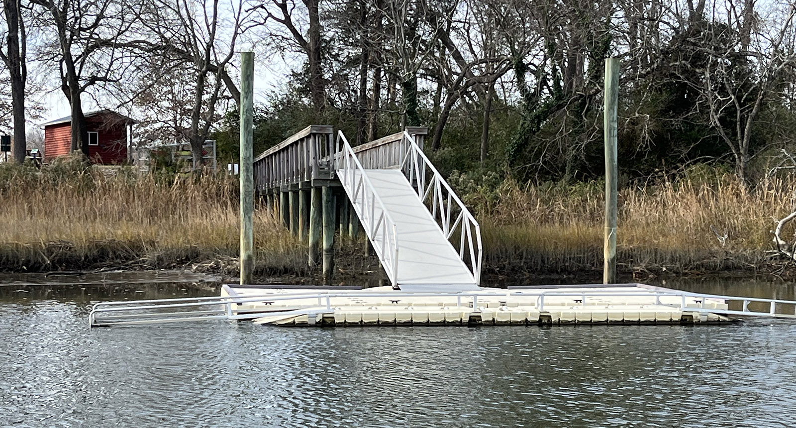 صورة لمزلق قوارب الكاياك المصنوعة من الألومنيوم تبرز في مياه النهر من الضفة.