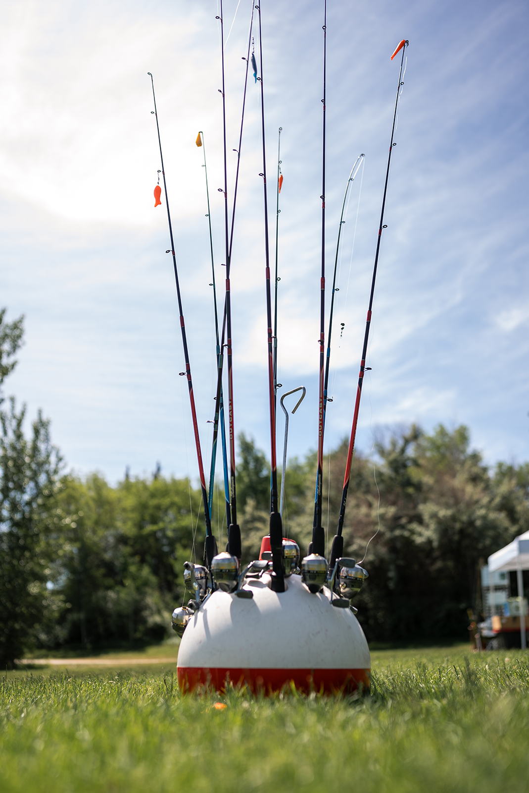 صورة لعدد من صنارات الصيد تبرز من حامل على شكل عوامة كبيرة.