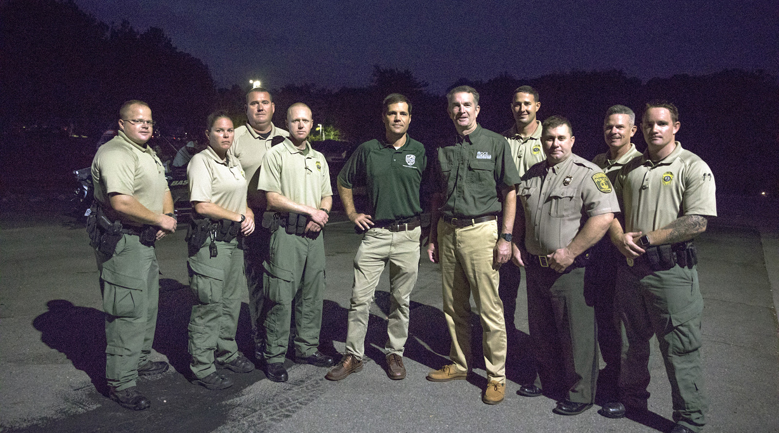 A photo of Ryan Brown (center) and Governor Northam with eight uniformed Conservation Police Officers.