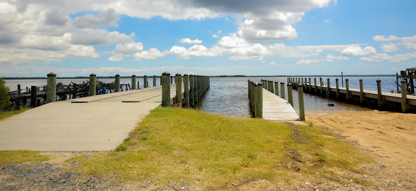 صورة لمنحدر قارب على اليمين ورصيف على اليسار يمتد إلى الماء.