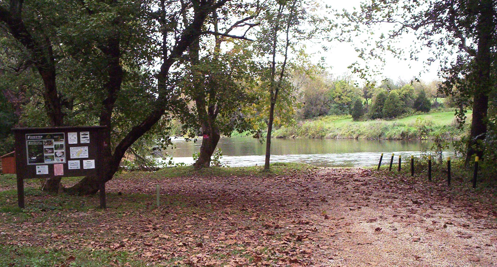 صورة لبحيرة تؤدي إلى موقع وصول قوارب DWR مع لوحة إعلانات خشبية في المقدمة