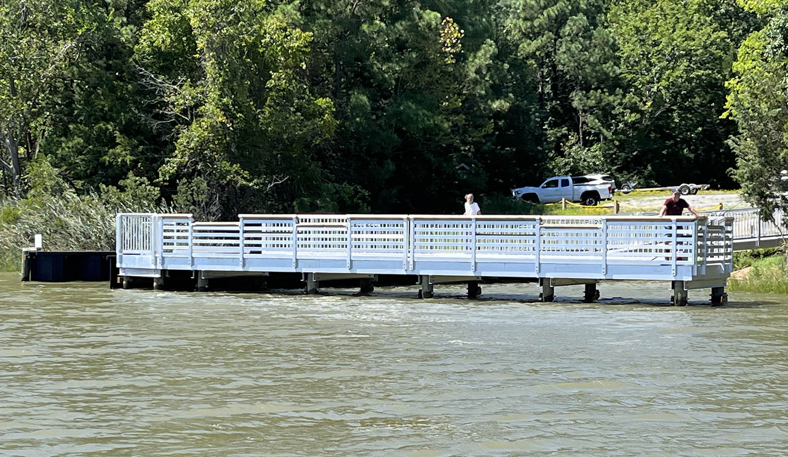 صورة لرجل يرتدي قميصاً أحمر ويقف على رصيف صيد معدني أبيض