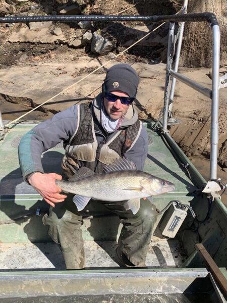 عالم أحياء متخصص في مصايد الأسماك تابع لإدارة الموارد المائية DWR يحمل سمكة